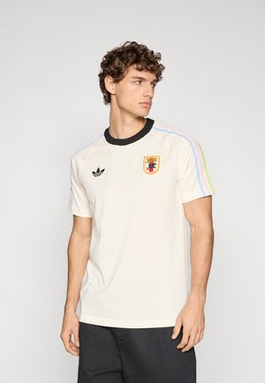 T-shirt blanc à manches courtes avec col côtelé noir, rayures bicolores sur les épaules et logo brodé sur la poitrine. Coupe décontractée avec une texture lisse.