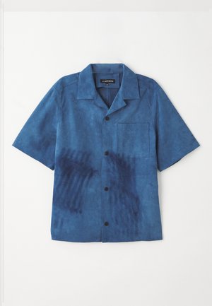 Camisa azul de manga corta hecha de una tela suave, con un bolsillo frontal, botones negros y una textura única con patrones en azul más oscuro.