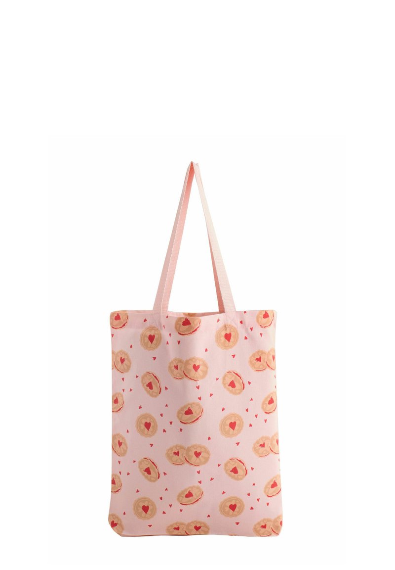 Rožnato platnena torba z vzorcem piškotov v obliki src, okrašenih z rdečimi srci, dvema trdnima ročajema in ravnim dizajnom.