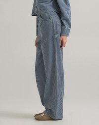 Blauwe en witte gestreepte brede broek van denim, met een hoge taille, twee voorzakken en een relaxte pasvorm. Aangevuld met messing beslag.