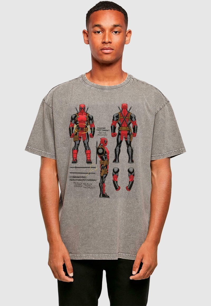 Gray oversized t-shirt featuring a graphic design of a character in red and black with text elements, round neck, and short sleeves.