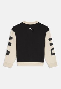 Sudadera de pullover negra y beige con mangas largas. Presenta un logo blanco en la parte posterior y un gran texto negro en las mangas. Textura de tela suave.