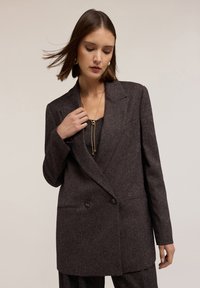 Dunkelgrauer, wollgemischter Blazer mit taillierter Passform, doppelten Knöpfen und Reverskragen; verfügt über eine subtile Textur und Seitentaschen.