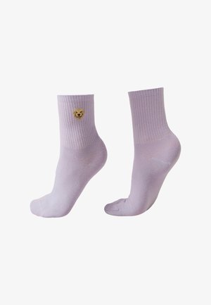 Lawendowe skarpetki do kostek z prążkowanymi ściągaczami, na jednej z nich znajduje się mała haftowana twarz psa rasy golden retriever blisko górnej krawędzi.