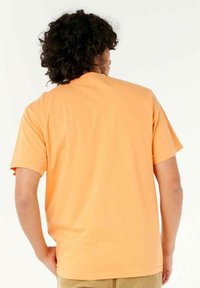 Orange Baumwoll-T-Shirt mit kurzen Ärmeln und lockerer Passform. Sanfte Textur, runder Ausschnitt und keine sichtbaren Muster oder Akzente.