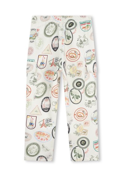 Pantalons en tissu blanc présentant un imprimé multicolore de divers timbres de voyage et emblèmes, avec poches et coupe décontractée.