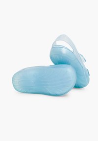 Translucent blue sandals with a textured sole, featuring a back strap and an open design for ventilation. Lightweight, flexible material.