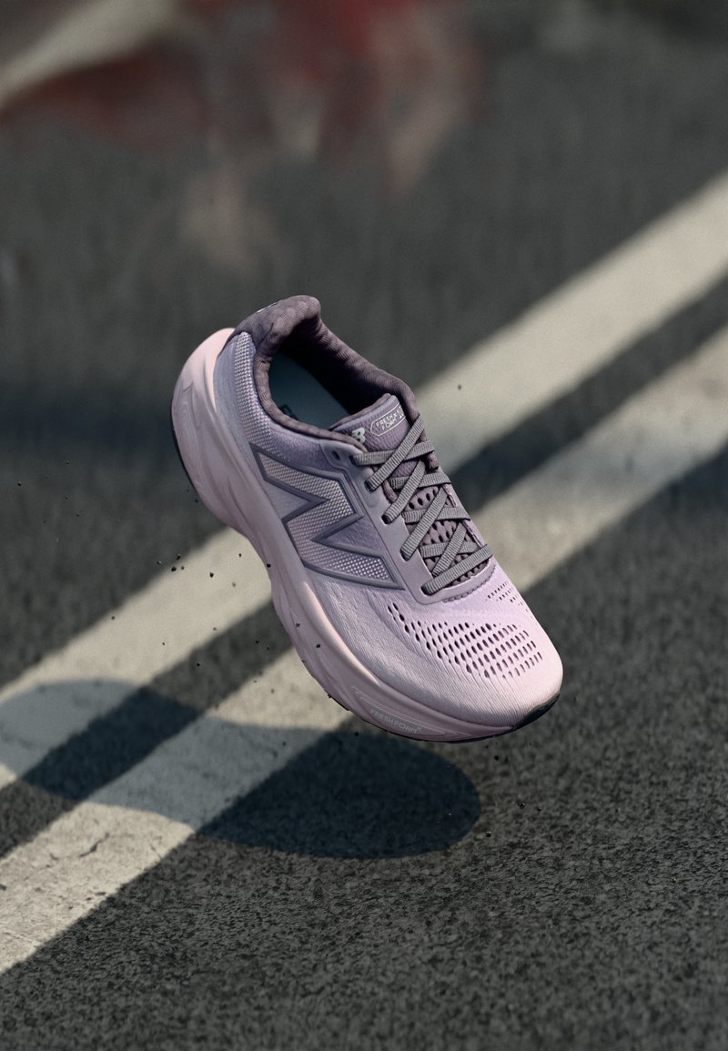 Baskets de course violet clair avec tige en maille, col rembourré et semelle texturée, présentant un logo bien visible sur le côté et des trous de ventilation.
