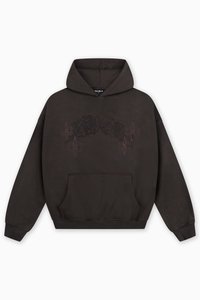 Tamnosmeđa majica s kapuljačom i prednjim džepom. Sadrži suptilan dizajn čipkastih uzoraka i ljiljana u tamnijoj nijansi. Mekana tekstura.