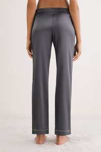 Šedé saténové pyžamové kalhoty s volným střihem, s elastickým pasem a kontrastním lemem na spodním okraji. Měkká textura, hladký vzhled.