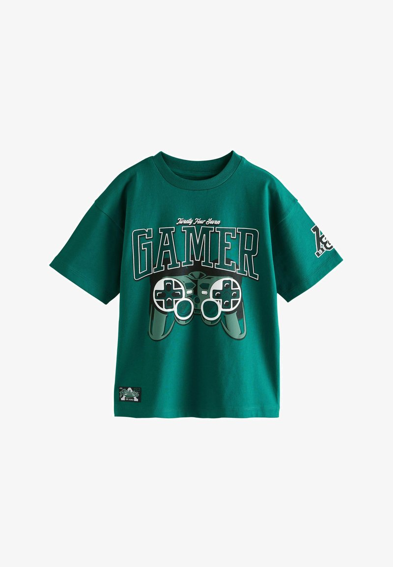 Grünes Baumwoll-T-Shirt mit einem großen "GAMER"-Grafikdesign, das einen Videospielcontroller zeigt. Kurze Ärmel, Rundhalsausschnitt und Etikett am Saum.