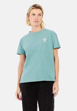 Licht turquoise katoen t-shirt met een relaxte pasvorm, voorzien van een kleine witte palmbomenafbeelding op de linker borst. Korte mouwen en een ronde hals.