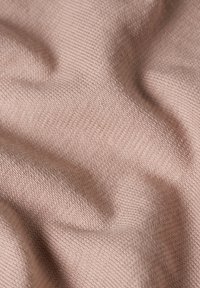 Tela suave y texturizada de tono rosa claro, con un patrón acanalado y una superficie lisa, ligeramente elevada.