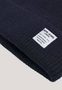 Mornarica pletena kapa od teksturirane vune, sa bijelom etiketom na kojoj je crnim slovima ispisano "Pepe Jeans London".