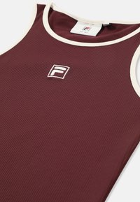 Vinröd ribbad linne med vit kant och en broderad logotyp. Tyget verkar slätt med en lätt stretch.