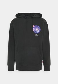 Sudadera con capucha negra, bolsillo canguro en la parte delantera y un gráfico circular floral colorido en el lado izquierdo del pecho.