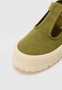 Καφέ ελαφρύ ύφασμα slip-on παπούτσι με στρογγυλή μύτη, διαθέτοντας ελαφριά μπεζ ελαστική σόλα και πλευρικές κοπές για αερισμό.