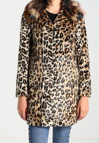 Kabát z umělé kožešiny s leopardím potiskem, širokým límcem, dlouhými rukávy a měkkou texturou. Na límci je černý akcent.