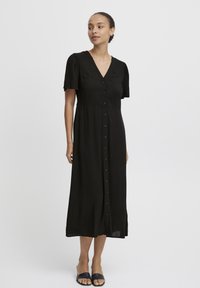 Vestido negro con botones, escote en V, mangas cortas abullonadas y una silueta fluida, hecho de una tela ligera.
