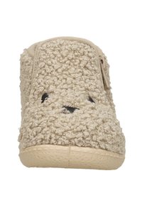 Beige plush slipper with a textured surface, round shape, and subtle black stitched facial features. Flexible rubber sole.
