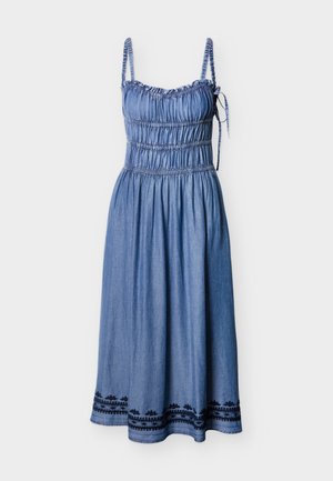 Robe en denim avec bretelles spaghetti réglables, corsage froncé et jupe à étages. Présente des accents brodés noirs à l'ourlet.