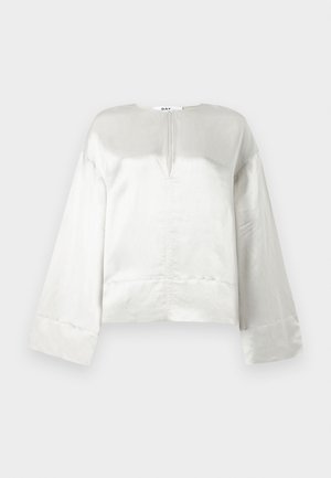 Svetle šedá zkrácená blůza s kulatým výstřihem, dlouhými rukávy a předním výrezem. Vyrobena z hladké tkaniny s mírným leskem.