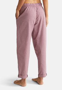 Rood-wit geblokte pyjamabroek met een elastische tailleband, zijzakken en opgerolde manchetten, gemaakt van een lichte stof.