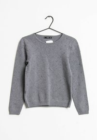 Maglione grigio lavorato a maglia con scollo tondo, maniche lunghe, motivo strutturato e orlo a coste. Realizzato in materiale morbido e caldo. Appeso a un gancio nero.