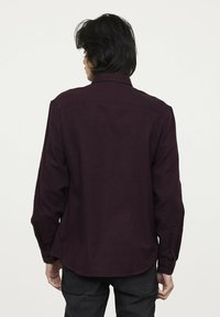 Bordeaux shirt met lange mouwen, knoopsluiting bij de manchetten en een klassieke kraag. Gemaakt van gestructureerde stof, met een rechte snit en een shirt-tail zoom.
