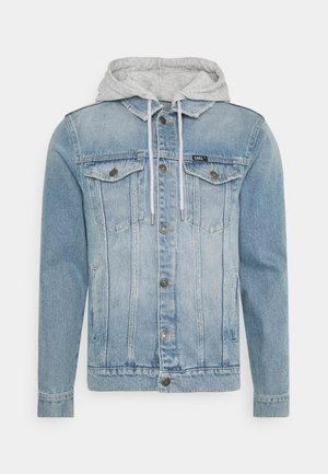 Lyseblå denimjakke med forreste knapper, brystlommer og en tilhæftet lysegrå hætte med hvide snore.