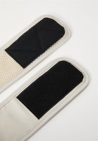 Two padded straps: one features a mesh surface, while both have black Velcro sections. Edges are stitched with white thread for durability.