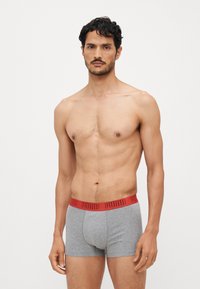 Szürke pamut boxer alsónadrág piros rugalmas derékkal, amelyen a "PUMA" logo található. Sima textúrájú és testhez simuló kialakítás, mindennapi viseletre alkalmas.