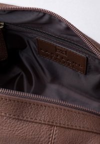 Brown leather bag with open zipper, showing dark fabric interior and a stitched label reading "Lakeland Leather."