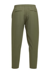 Pantalon vert olive ajusté avec taille élastique et deux poches passepoilées à l'arrière sur fond uni.