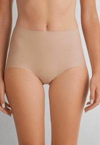 Beiga högmidjade trosor i mjukt, stretchigt tyg med en slät yta och sömlös design för komfort och flexibilitet.