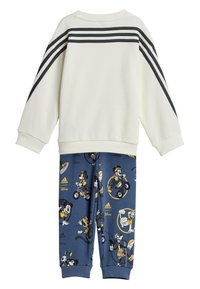 Felpa bianca con strisce nere sulle maniche, abbinata a pantaloni blu con motivi a cartone animato di personaggi Disney in accenti gialli.