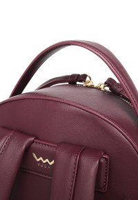 Maroon leather backpack with a rounded shape, featuring a top handle and gold hardware accents, including a logo detail and zipper.