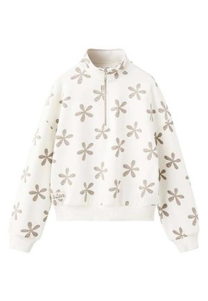 Sweat-shirt blanc à col zippé, présentant un motif floral argenté répété. Les poignets et l'ourlet sont côtelés, avec une petite étiquette sur le côté.