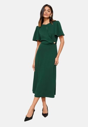 Grünes Midikleid mit Schmetterlingsärmeln, einem Wickeldesign und seitlichem Schlitz, das mit einem goldenen Akzent an der Taille versehen ist. Glattes, leichtes Material.