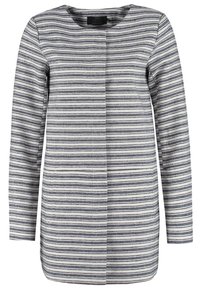 Giacca da donna a maniche lunghe, senza colletto, con righe orizzontali nere e bianche e chiusura frontale nascosta.