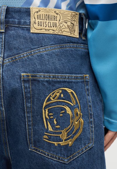 Τζιν από τζην ύφασμα με δερμάτινο ετικέτα που γράφει "Billionaire Boys Club" και χάλκινο κεντημένο κράνος αστροναύτη στην πίσω τσέπη.