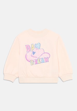 Pink sweatshirt with ribbed cuffs and hem. Features a glittery "DA DREAM" graphic and a heart-shaped hat design in pastel colors.