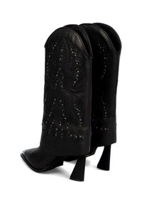 Botas de vaquero de cuero negro con punta afilada, costuras decorativas y acentos de remaches. Presentan un sólido tacón cuadrado y un caña alta.