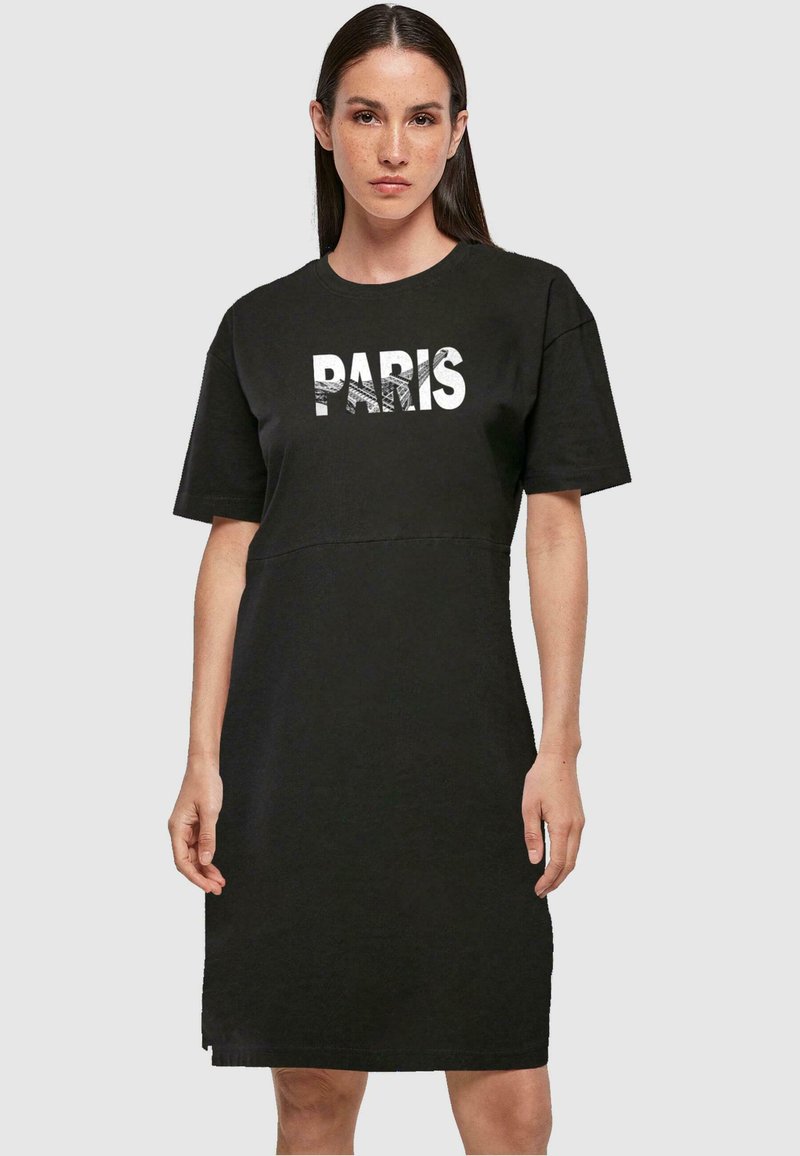 Černé krátké šaty s tričkovým rukávem s bílým nápisem "PARIS", měkkou texturou a rovný fit. Délka do kolen s jednoduchým designem.