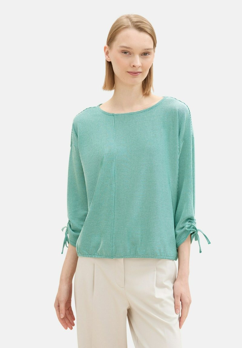Türkiser gerippter Oberteil mit Dreiviertelärmeln, seitlichen Bindebändern und einer lockeren Passform. Das Design zeichnet sich durch horizontale Streifen und einen weiten Ausschnitt aus.