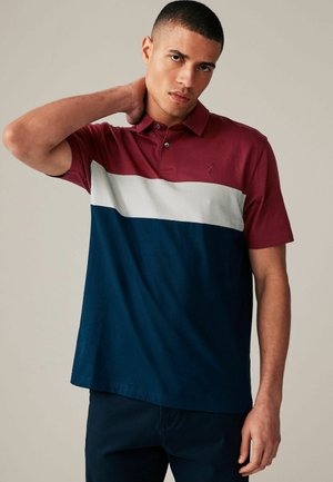 Polo majica s bordo gornjim dijelom, bijelim mrežastim prugom i tamnoplavim donjim dijelom. Kratki rukavi, ovratnik i suptilna detalj s logotipom na prsima.