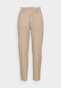 Pantalones beige de talle alto con una cintura elástica, perneras ajustadas y bolsillos frontales. Fabricados en una tela de algodón texturizada.