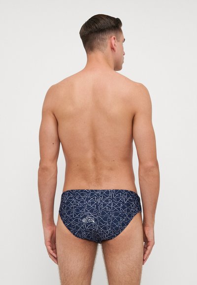 Marine zwemslips met een wit vispatroon, elastische tailleband en logo. Heeft een aansluitend ontwerp en een gladde textuur. Achteraanzicht getoond.