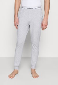 Grijze katoenen joggingbroek met een zwarte tailleband met het label "BJÖRN BORG," gesneden met taps toelopende benen en geribbelde boorden voor een strakke fit.