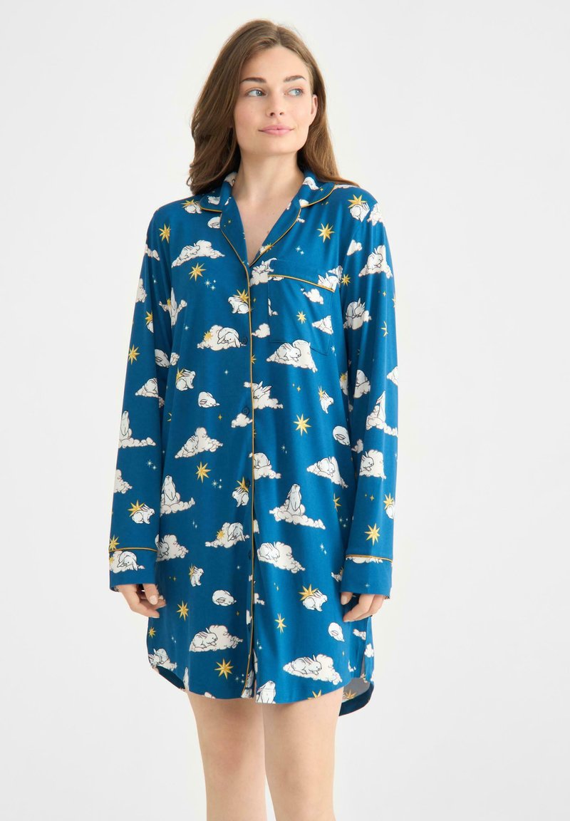 Túnica de pijama azul con motivos de nubes, estrellas y osos polares. Fabricada en tela suave, con mangas largas, un cuello y un bolsillo delantero.